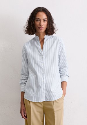 Lichtblauwe en witte verticale gestreepte overhemden met een bandkraag en opgerolde mouwen, gecombineerd met beige broek.
