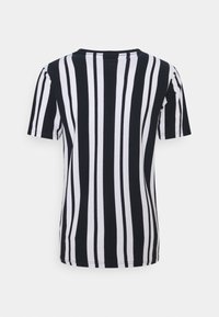 Musta-valkoinen raitapaita lyhyillä hihoilla, jossa on pyöreä kaula-aukko. Paidassa on pystysuoria raitoja, joiden leveydet vaihtelevat, ja se on valmistettu sileästä kankaasta.