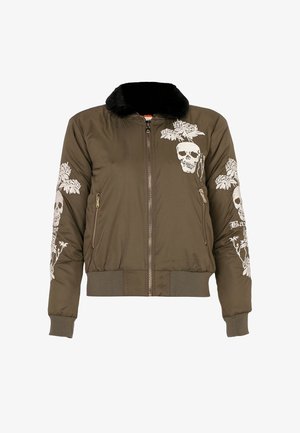 Veste bomber olive avec col en fourrure noire, fermeture éclair frontale, poches latérales, et broderie blanche de crânes et de fleurs sur les manches et la poitrine.