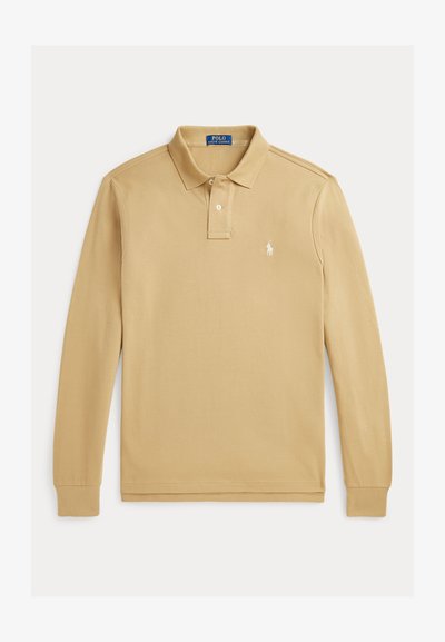 Gaiļbalta polos krekls ar garām piedurknēm, izgatavots no kokvilnas, ar divu pogu apkakli, izšūtu logo krūšu daļā un ribotiem piedurkņu galiem.