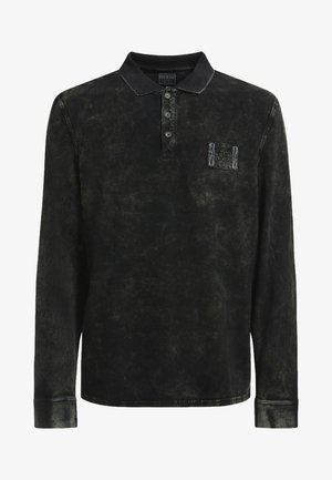 Polo noir à manches longues avec une texture délavée, une patte de boutonnage à trois boutons et un petit écusson brodé sur la poitrine gauche.