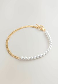 Zlatý náramok s retiazkou, ktorý obsahuje striedajúce sa časti metalických strieborných korálkov a jemné zapínanie na klips. Hladký povrch s lesklým finišom.