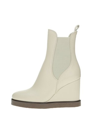 Stivale ankle bianco con tacco a cuneo realizzato in pelle testurizzata, dotato di pannelli laterali elasticizzati, punta arrotondata e suola marrone a contrasto.