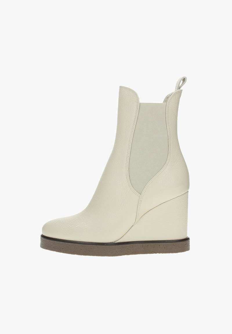 Stivale ankle bianco con tacco a cuneo realizzato in pelle testurizzata, dotato di pannelli laterali elasticizzati, punta arrotondata e suola marrone a contrasto.