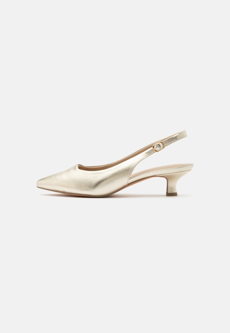 Chaussure slingback dorée à bout pointu, petit talon kitten et bride réglable avec boucle sur un fond blanc uni.