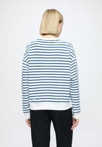 Sweat-shirt rayé bleu et blanc avec col rond et poignets côtelés, doté d'une coupe décontractée et d'un tissu en coton doux.