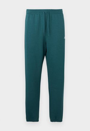 Turkis sweatpants lavet af blødt stof, med elastisk taljebånd og snøre, samt tilspidsede ben med elastiske manchetter.
