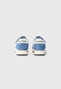 Plave suede tenisice s bijelim detaljima, s podstavljenim ovratnikom, kontrastnim vezicama i gumenim potplatima. "CONVERSE" logo na peti.