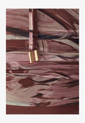 Textuurstof in tinten van roze en bruin met abstracte patronen, met een opvallende rits met gouden hardware-accenten.