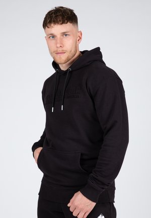 Zwarte hoodie van een katoenmix, met een voorzak, trekkoorden, een reliëflogo op de borst, ribgebreide manchetten en zoom. Soepele textuur.