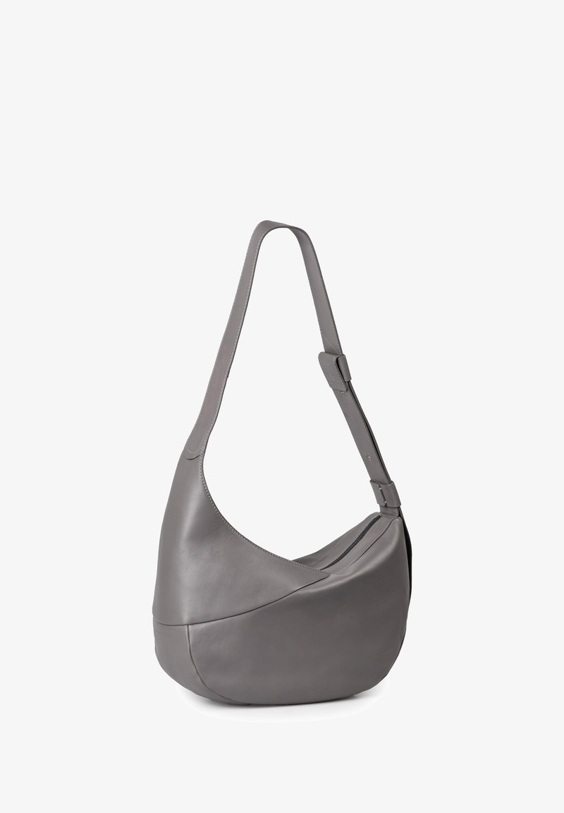 Gray leather shoulder bag with a curved design, adjustable strap, and a zippered compartment. Smooth texture and minimalist style.