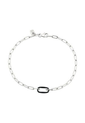 Sølvkædearmbånd med rektangulære led og et centralt sort led, sikret med en låsehage og en lille mærkat nær låsen.