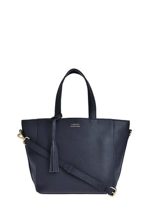 Sac fourre-tout en cuir bleu marine avec deux poignées, une bandoulière réglable et un détail de pompon. Texture lisse avec un design minimaliste et des finitions en or.