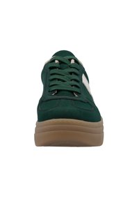 Green suede sneaker with a rubber sole, featuring a white side stripe, round toe, and flat laces, displaying contrast stitching details.