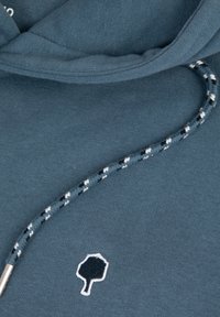 Felpa con cappuccio in tessuto teal, con logo bianco a forma di albero, cordoncino testurizzato con un motivo bianco e nero e materiale morbido e testurizzato.