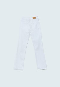 Jean blanc droit posé à plat montrant les poches arrière et un patch logo en cuir marron sur la ceinture.