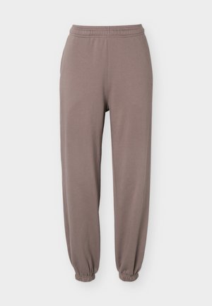 Šviesiai rusvos spalvos laisvalaikio kelnės su elastinga juosmens juosta ir rankogaliais, tiesaus kirpimo, pateiktos ant balto fono.