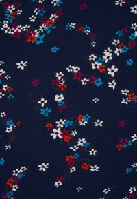 Petit motif floral avec des grappes de fleurs blanches, bleues, rouges et marron sur un fond bleu marine foncé.