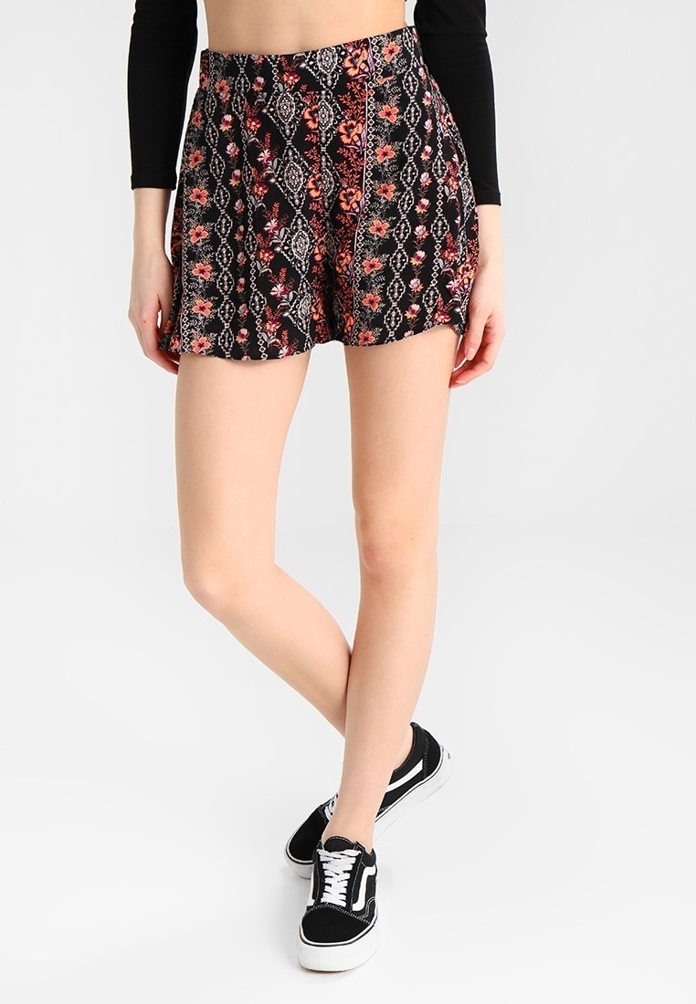Pantalones cortos negros con un patrón floral y geométrico en rojo y blanco. Fabricados con una tela ligera, cuentan con una cintura fruncida y un ajuste relajado.