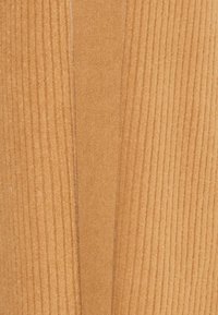 Tessuto a coste in una calda tonalità giallo-arancio, con texture verticali e orizzontali lisce. Il dettaglio delle cuciture corre verticalmente lungo il centro.