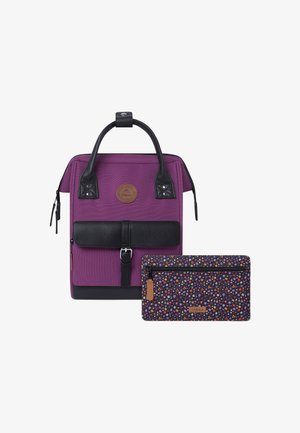 Paarse rugzak met zwarte leren accenten en een sluitflap aan de voorkant. Inclusief een kleine tas met bloemmotief. Duurzaam stof en gestructureerd ontwerp.