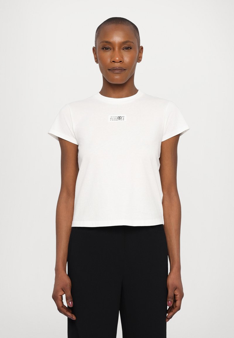 White cotton t-shirt with short sleeves, crew neckline, and a square graphic detail on the chest. Simple design and relaxed fit.