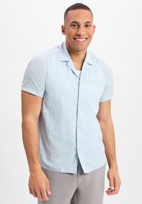 Hellblaue kurzärmlige Button-Up-Bluse mit einem Palmenblattmuster, ausgestattet mit einem Eingriffkragen und beigen Knöpfen. Glatte Textur, legere Passform.