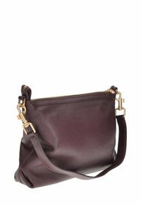 Borsa a mano in pelle borgogna con finitura testurizzata, chiusura con zip e appendici in metallo dorato. Dotata di una tracolla rimovibile per maggiore versatilità.