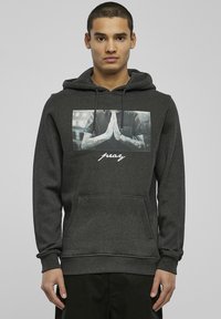 Dark gray hoodie with a front pocket, featuring a photo print of hands in a prayer position and the word "pray" in white cursive text.