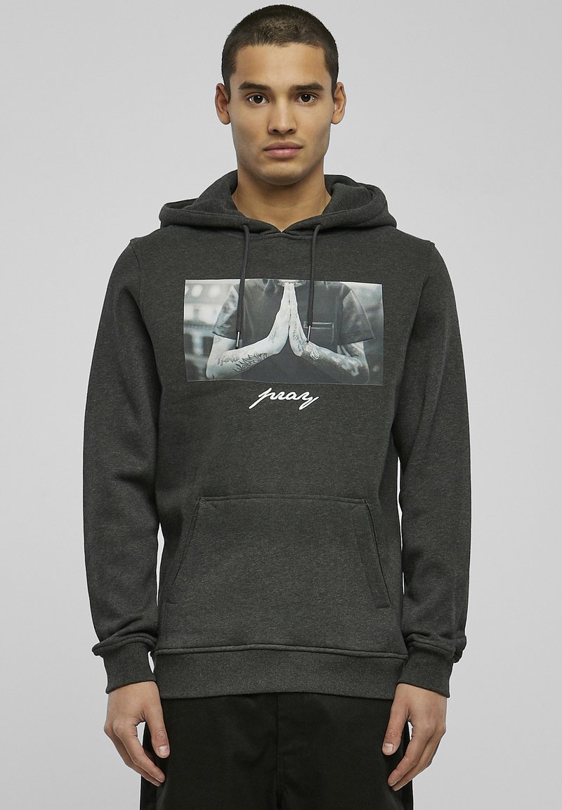 Dark gray hoodie with a front pocket, featuring a photo print of hands in a prayer position and the word "pray" in white cursive text.
