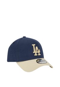 Marineblaue Baseballmütze mit beigem Schirm, versehen mit einem gestickten "LA"-Logo in Creme. Hergestellt aus weichem Stoff, mit verstellbarem Riemen auf der Rückseite.