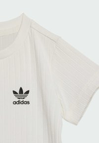 Camiseta blanca de Adidas de manga corta con canalé, que presenta un logotipo negro de trébol centrado debajo del cuello.