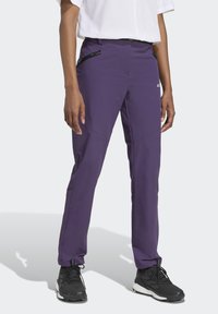 Pantaloni sportivi viola a vestibilità slim, con tasche con zip e tessuto morbido. Include cuciture rinforzate e un design con gamba affusolata.
