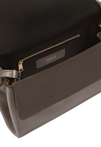Sac à main en cuir gris avec un extérieur doux et texturé et un intérieur lisse contrastant. Comprend une poche zippée et des éléments en métal doré.