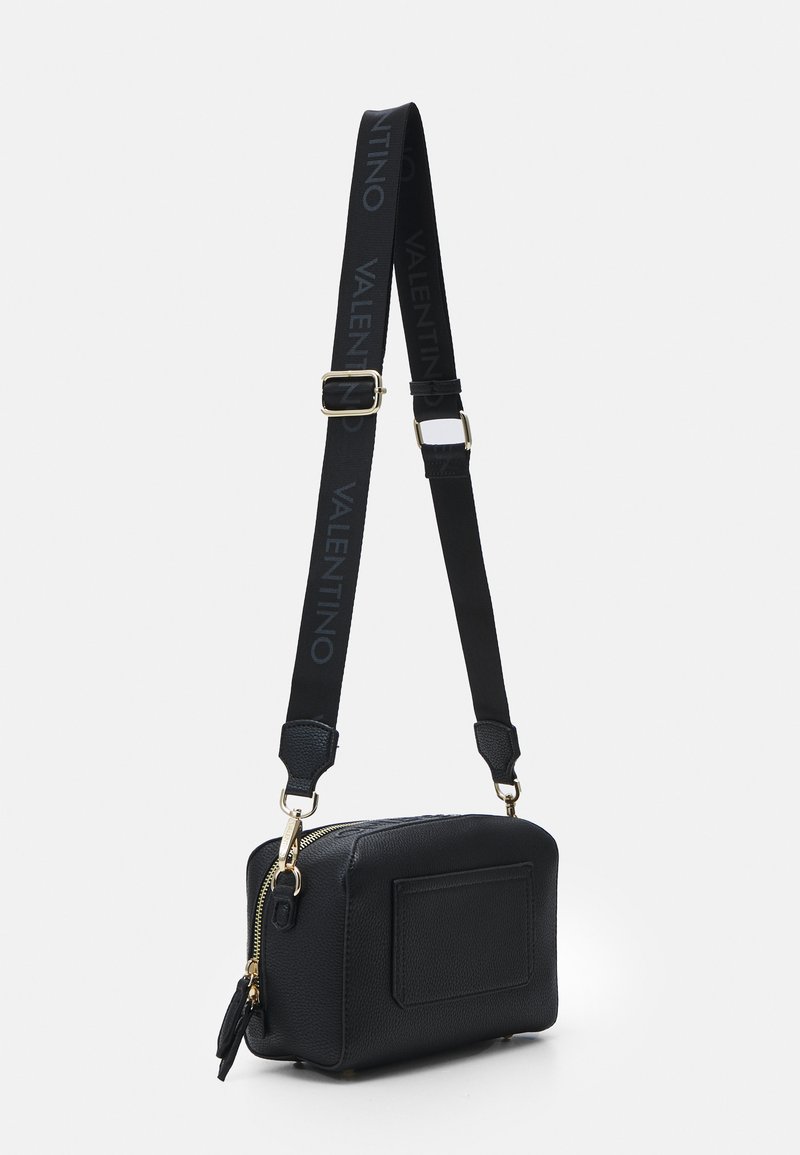 Bolso cruzado de cuero negro con acabado texturizado, que cuenta con cierre de cremallera, herrajes dorados y una correa ajustable con la marca "VALENTINO".