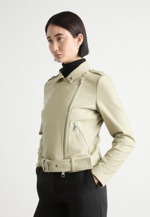 Giacca in faux pelle verde chiaro, aderente, con cerniera asimmetrica, colletto a scatto e vita con cintura. Presenta epaulettes sulle spalle e cerniere laterali.