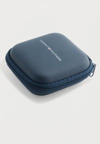 Funda con cremallera de color azul marino y textura suave, con el logo "TOMMY HILFIGER" en blanco y esquinas redondeadas.