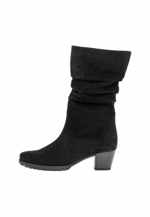Botte noire en suède à la cheville avec un haut flou, un bout arrondi et un talon épais. Surface texturée avec une semelle en caoutchouc pour une meilleure adhérence.