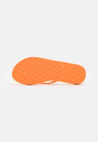 Semelle de sandale orange vif avec un motif texturé. Comprend deux accents circulaires sur le dessous pour l'adhérence et la stabilité.