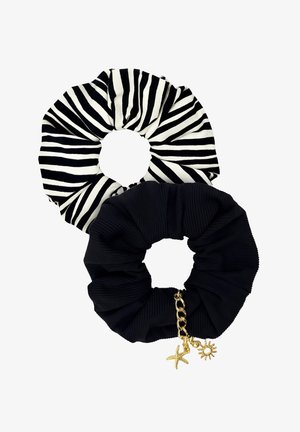Dwa materiałowe gumki do włosów, jedna czarna z złotymi zawieszkami w kształcie słońca i rozgwiazdy, druga w zebrowe czarno-białe paski.