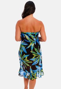 Vestido negro sin tirantes con vibrantes patrones florales en azul y verde, que presenta un dobladillo con volantes y una textura de tela ligera y fluida.