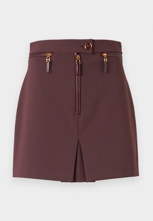 Burgundy mini skirt with a slim fit, featuring a front zip, decorative zippers, a slit, and a button closure with gold accents.