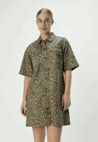 Robe à imprimé léopard en tissu texturé, dotée de manches courtes, d'un devant à boutons et d'un col. Comprend des poches avant.