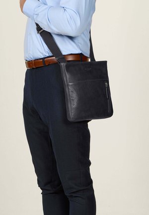 Schwarze Leder-Schultertasche mit glatter Textur, ausgestattet mit einer vorderen Reißverschlusstasche und einem verstellbaren Gurt. Eignet sich für den lässigen oder formellen Gebrauch.