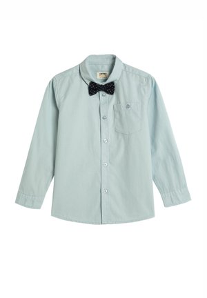 Camisa de manga larga azul claro con cuello abotonado, que presenta una pajarita con puntos negros y un pequeño bolsillo en el pecho.