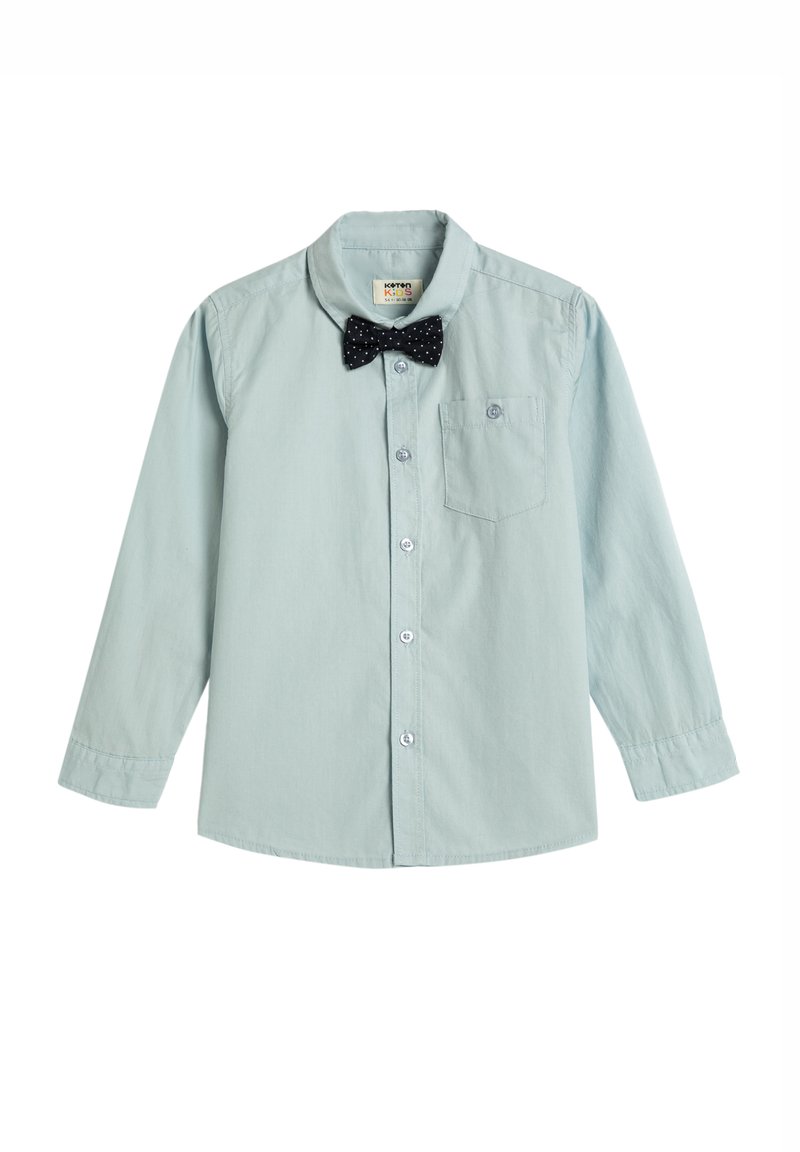 Camisa de manga larga azul claro con cuello abotonado, que presenta una pajarita con puntos negros y un pequeño bolsillo en el pecho.