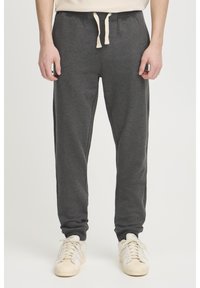 Grå sweatpants i blødt stof med elastisk talje og snor. Tapered ben-design med ribbede manchetter ved anklerne.