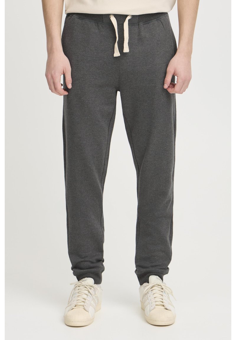 Grå sweatpants i blødt stof med elastisk talje og snor. Tapered ben-design med ribbede manchetter ved anklerne.