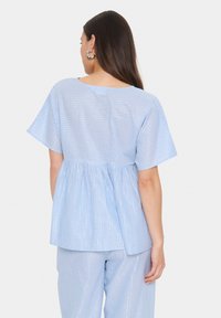 Light blue striped top with short sleeves and gathered waist. The material appears smooth with a subtle sheen. Back view displayed.