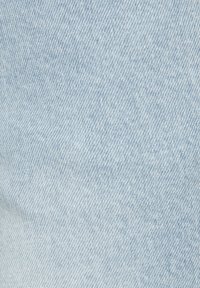 Gai zils denima audums ar gludu tekstūru un izteiksmīgu šuvju rakstu, kuram ir smalkas krāsu un ēnu variācijas.